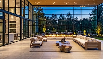 Luxurious outdoor living space with glass walls and a fire feature